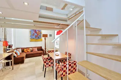 a living room with a staircase and a table and chairs at Design Loft Campo dei Fiori in Rome