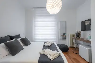 a bedroom with a large white bed with black pillows at 500 Suite Prati delle Vittorie in Rome