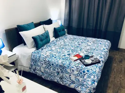 a bedroom with a bed with a blue and white comforter at Mamma Roma 151 in Rome
