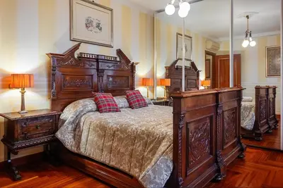 a bedroom with a large wooden bed with red pillows at Regal House Roma Navigatori 23 in Rome