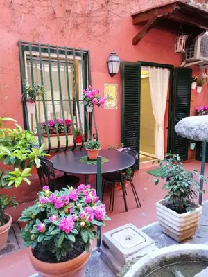 a patio with a table and chairs and flowers at La Calla al Colosseo in Rome