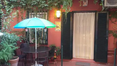 a table with a blue umbrella in front of a building at La Calla al Colosseo in Rome