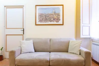 a couch in a living room with a picture on the wall at Sunny Home in Rome