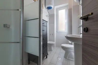 a white bathroom with a toilet and a sink at San Paolo Steampunk Flat in Rome