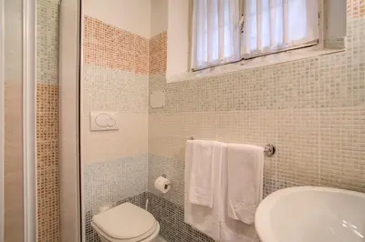 a bathroom with a toilet and a sink at Navona Gallery Suites in Rome