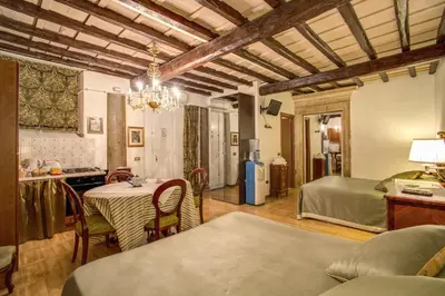 a kitchen and living room with a table and a bed at Navona Gallery Suites in Rome