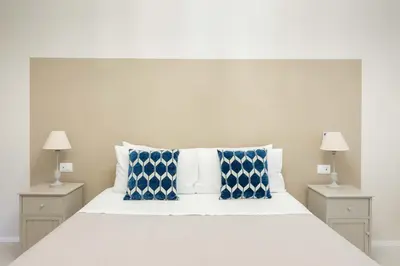 a bedroom with a white bed with blue and white pillows at SuityRHome RioneMonti54 in Rome