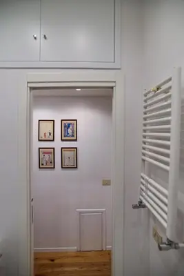 a hallway with a door with three pictures on the wall at the blu and green apartment in Rome