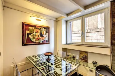 a dining room with a glass table and a painting at Spacious Flat by Piazza Navona in Rome