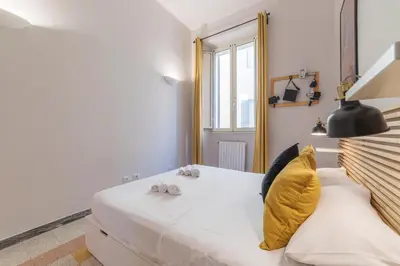 a bedroom with a large white bed with yellow pillows at Casa Fellini - Charme Holidays in Rome