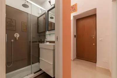 a bathroom with a shower and a sink and a door at Casa Fellini - Charme Holidays in Rome
