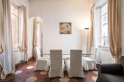 a dining room with a table and chairs and windows at Casa Coronari Holidays in Rome