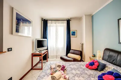 a bedroom with a bed and a television and a couch at Sunrise Apartment in Rome