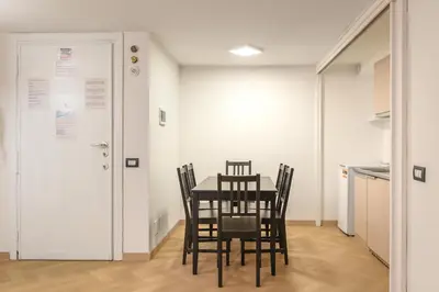 a table and chairs in a room with a kitchen at Orso Apartment in Rome