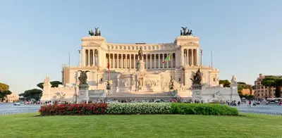 a large building with a grassy field in front of it at Orso Apartment in Rome