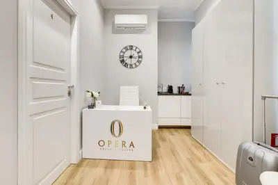 a white room with a door and a clock on the wall at Opera Private Suites by Premium Suites Collection in Rome