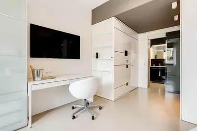 a white home office with a desk and a tv at EMERALD Luxury Suite Apartment in Rome