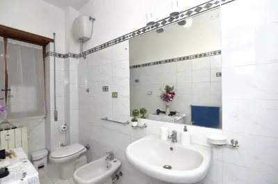 a white bathroom with a sink and a toilet at Roma Tiberius Suite in Rome