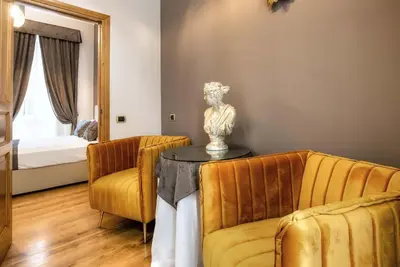 a living room with a couch and a table with a statue at Hotel Paba in Rome