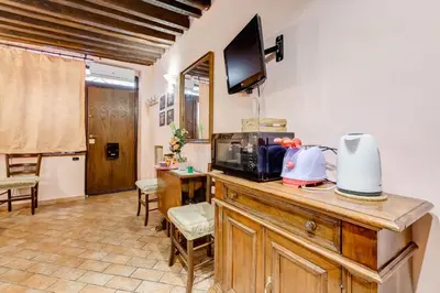 a room with a counter with a microwave and a television at Colosseum Rione Monti 1 in Rome
