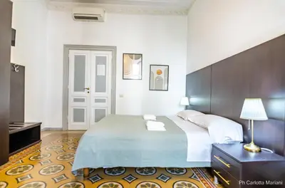 a bedroom with a bed and a table with a lamp at El Dorado Colosseum in Rome