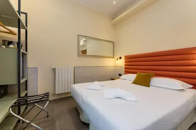 a bedroom with a large white bed and a mirror at Seven in Rome
