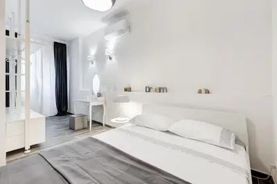 a white bedroom with a bed and a bathroom at The Miki House in Rome