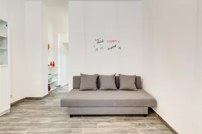 a bed in a room with a white wall at The Miki House in Rome