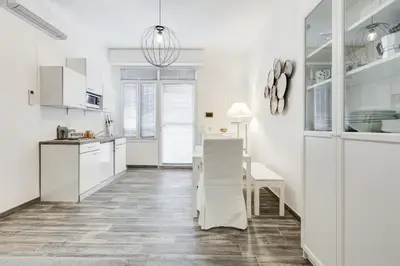 a kitchen and dining room with white cabinets and a table at The Miki House in Rome