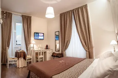 a bedroom with a bed and a desk and a window at Relais de l'Opera in Rome