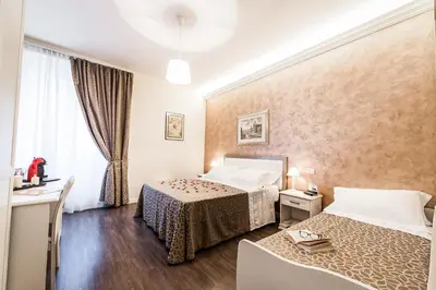 a hotel room with two beds and a window at Relais de l'Opera in Rome
