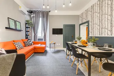 a living room with an orange couch and a table at TRIDENTE Apartment in Rome