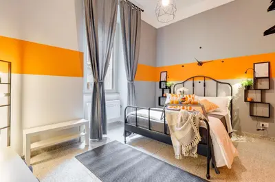 a bedroom with orange and gray walls and a bed at TRIDENTE Apartment in Rome