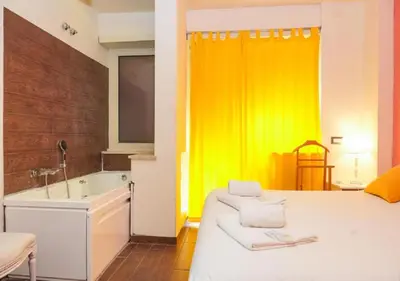 a bathroom with a bed and a sink and a tub at Aida Charming Rooms in Rome