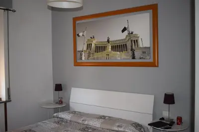 a bedroom with a picture of a building on the wall at B&B Lost in Rome in Rome