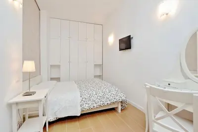 a white dining room table with white chairs and a newspaper at Deco's Place Roma Zoe in Rome