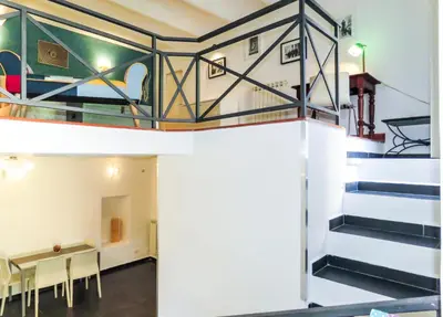 a room with a staircase and a table and chairs at Casa del Moro - romantic loft in Trastevere in Rome