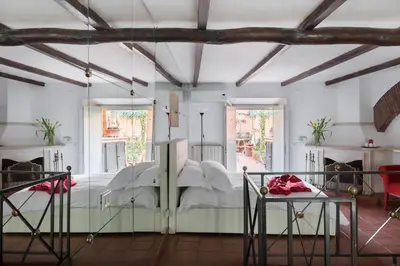 a bedroom with a bed in a room with windows at Cedro Terrace&Jacuzzi - Loft in Trastevere in Rome