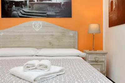 a bed with a white towel on top of it at Restart Zingari Rome in Rome