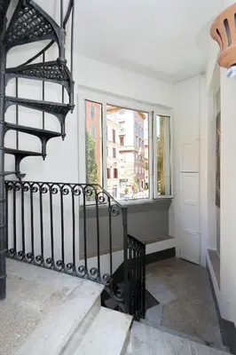 a black spiral staircase in a white room with a window at Restart Zingari Rome in Rome