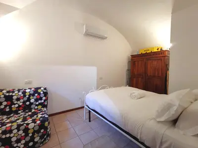 a small bedroom with a bed and a chair at Colosseo Home - 29061 in Rome