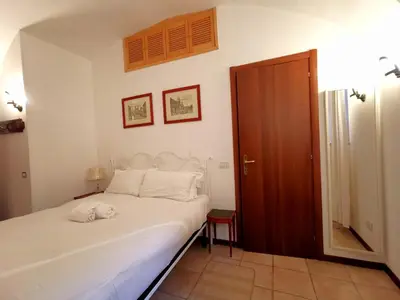 a bedroom with a white bed and a wooden door at Colosseo Home - 29061 in Rome
