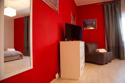 a red room with a television and a mirror at San Silverio Luxury House in Rome