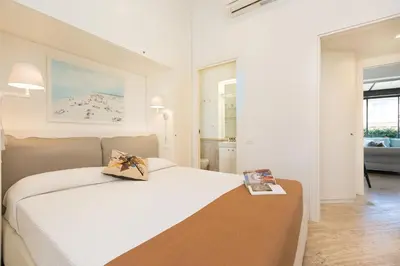 a bedroom with a white bed with a book on it at Amazing Penthouse Piazza Venezia in Rome