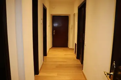 a hallway with black doors and wooden floors at R.T. HOUSE'S in Rome