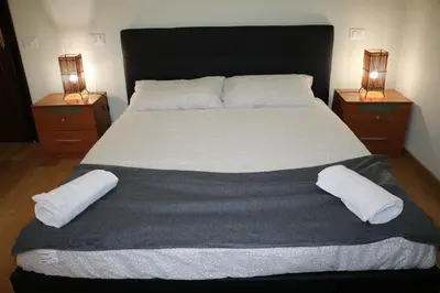 a bedroom with a large bed with two night stands at R.T. HOUSE'S in Rome