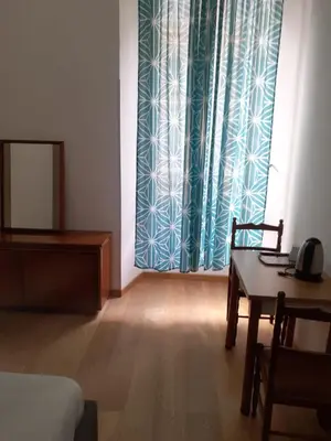 a room with a bed and a table and a window at R.T. HOUSE'S in Rome