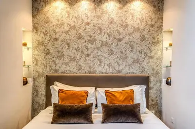 a bedroom with a large bed with orange pillows at Maison Babuino in Rome