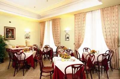 a dining room with tables and chairs and windows at Hotel Demetra Capitolina in Rome