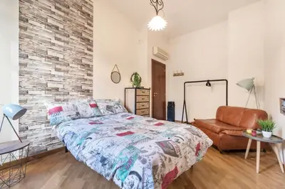 a bedroom with a bed and a brick wall at Re Di Roma Vintage Apartment in Rome